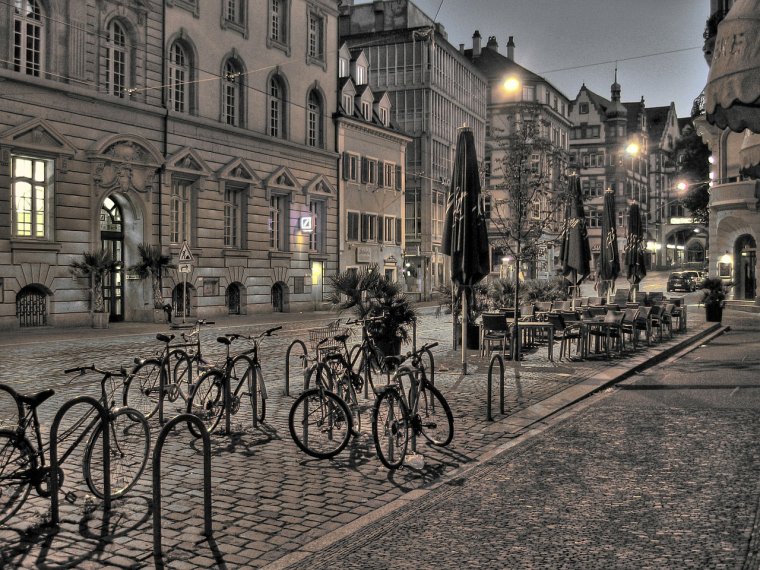 Una foto de una calle con estacionamiento de bicicletas